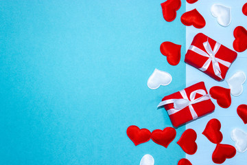 Happy Valentines Day. Background for Valentine's Day with red and white hearts and gifts. Congratulation on Valentine's Day on a blue background. Horizontal top view, flat lay.