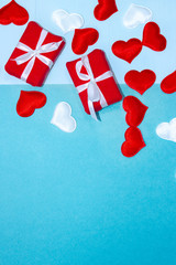 Happy Valentines Day. Background for Valentine's Day with red and white hearts and gifts. Congratulation on Valentine's Day on a blue background. Vertical top view, flat lay.
