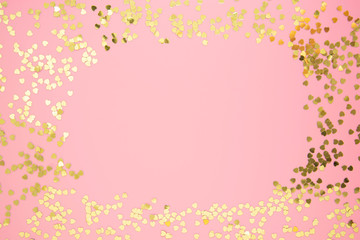 Abstract textured backgraund, golden heart shape glitter over pink background. Valentine's Day, love, birthday, party concept. Flat lay with copy space.