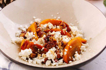 Winter dessert. caramelized persimmon with walnuts and cottage cheese