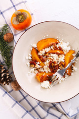 Winter dessert. caramelized persimmon with walnuts and cottage cheese