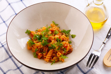 traditional pasta with meat and herbs in a beige plate