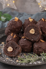 Obraz na płótnie Canvas Dark chocolate truffles with hazelnuts on plate.