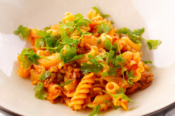 traditional pasta with meat and herbs in a beige plate