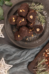 Dark chocolate truffles with hazelnuts on plate. Top view. Flat lay