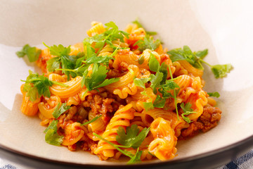 traditional pasta with meat and herbs in a beige plate