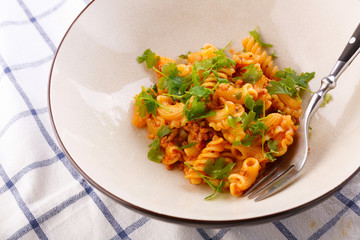 traditional pasta with meat and herbs in a beige plate