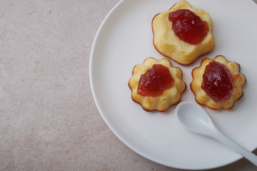 A portion of cottage cheese casserole with strawberry jam and peaches