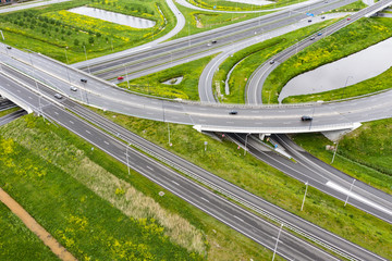 A cloverleaf highway with traffic in the middle of green fields near Waalwijk, Brabant, Netherlands