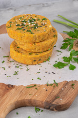 Raw veggie burger with chickpeas, vegetables and parsley leaves on kitchen countertop