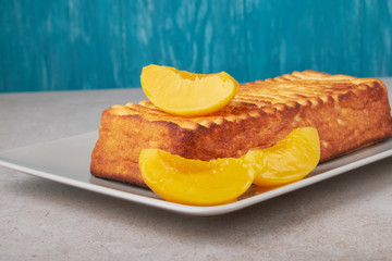 A portion of cottage cheese casserole with strawberry jam and peaches