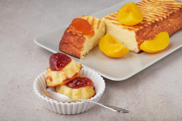 A portion of cottage cheese casserole with strawberry jam and peaches