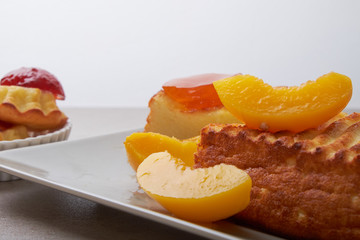 A portion of cottage cheese casserole with strawberry jam and peaches