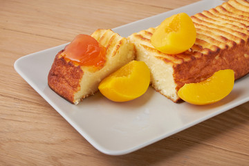 A portion of cottage cheese casserole with strawberry jam and peaches