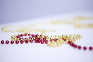 Different beads necklaces on white wooden table. Holiday. Christmas. New Year. different colors - red, yelow . Horizontal frame. Soft focus