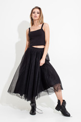 Fototapeta premium Girl in t-shirt and black skirt posing on a white background. Fashion shooting