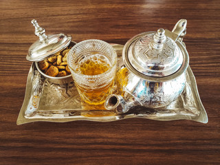 Top view of Moroccan tea pot with a cup of tea with some moroccan cakes on table - Moroccan Tea