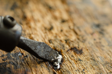 Macro shot of an electric soldering iron melts a tin. Copper sting of a used soldering iron melts a...