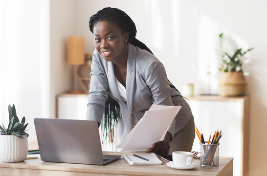 Afro Businesswoman Working With Documentation And Laptop In Modern Office