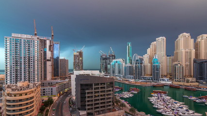 Luxury yachts parked on the pier in Dubai Marina bay with city aerial view timelapse
