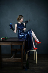 girl in a blue evening dress with a pipe