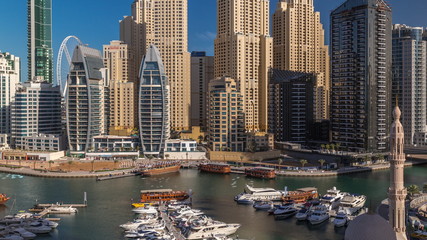 Fototapeta na wymiar Luxury yachts parked on the pier in Dubai Marina bay with city aerial view timelapse