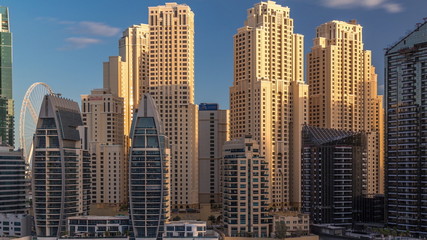 Obraz na płótnie Canvas Luxury yachts parked on the pier in Dubai Marina bay with city aerial view timelapse