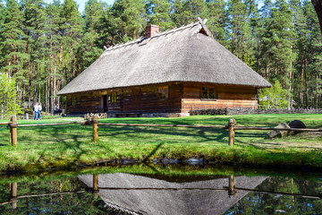 Fototapeta na wymiar Old wooden house on the shore of the pond, Latvia.