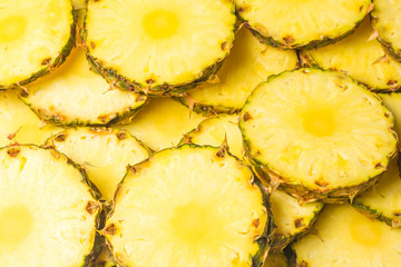 Pineapple juicy yellow slices background. Top view.