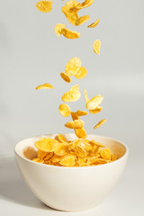 Corn flakes falling to the white bowl. Motion.