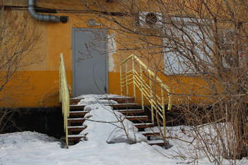 a locked door in a house with a porch covered in snow an unused emergency exit