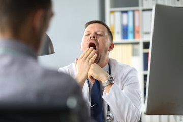 Doctor yawns while the patient has been talking about his problems for an hour.