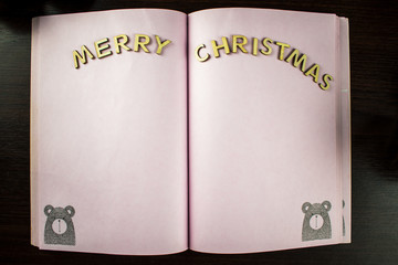 The boy writes a letter to Santa at night. Note for santa in notebook. Letter for santa on the table.k