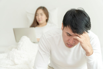 Depressed and Stressed Young Man Sits on the Edge of Bed in Morning time. Suffering From Insomnia Because of Sex Problems. Upset man having problem sitting on the bed with his girlfriend.