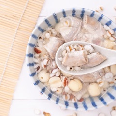Tasty Four Tonics Herb Flavor Soup, Taiwanese traditional food with herbs, pork intestines on white wooden table, close up, flat lay, top view.