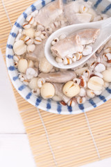 Tasty Four Tonics Herb Flavor Soup, Taiwanese traditional food with herbs, pork intestines on white wooden table, close up, flat lay, top view.