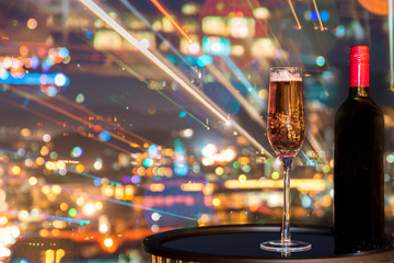 A glass of rose wine over light city blurred background and fireworks, Christmas festive...
