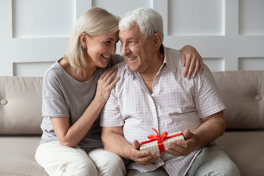 Happy older 70s man feeling thankful to wife for present.