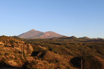 Mount Tiede at sunset behind rolling green hills