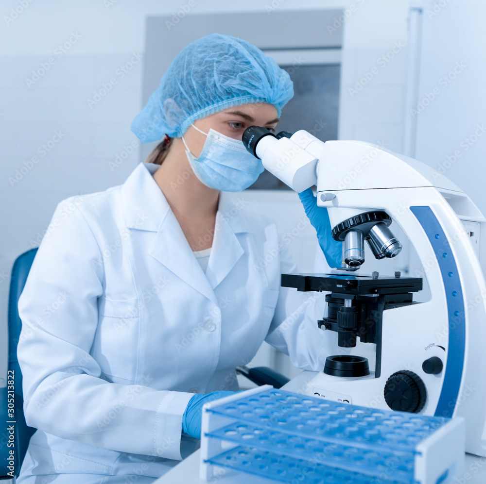 Poster Laboratory worker using modern microscope in mask and gloves