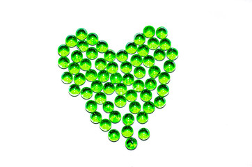 Green glass balls. Glass ball on a white background. Macro from different angles and in the form of a heart.