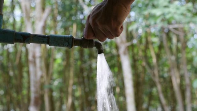 Hand off water valve with blur background of green nature, water saving concept, Hand close water valve to stop water drop from faucet, Energy conservative