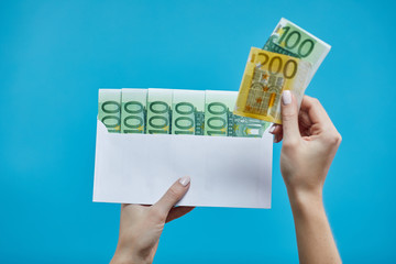 Female hands holding euro banknotes on a blue background. Euro Money. euro cash background