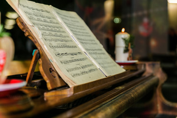 Old piano with music book and christmas decoration.Christmas time. Close up