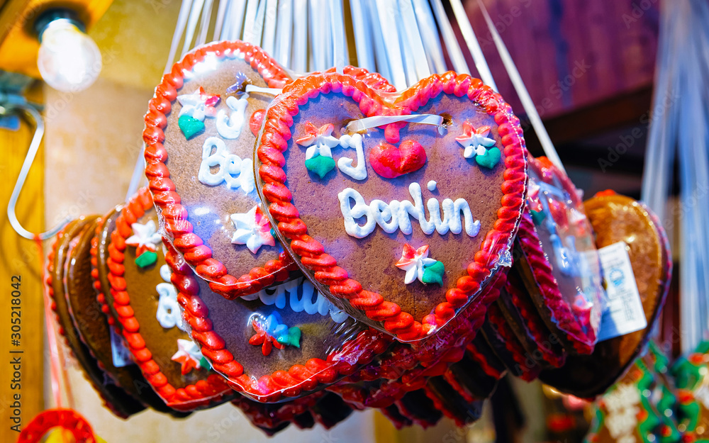 Sticker Heart shape Gingerbread cookies food on Christmas market in Europe in winter. German Night street Xmas and holiday fair in European city or town, December. Gendarmenmarkt in Berlin, Germany