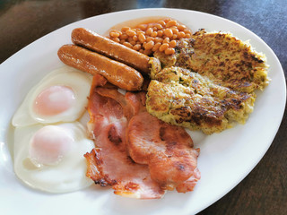 English Breakfast with bacon slices, eggs, baked beans, sausages and bubble and squeak.