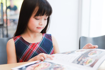 Asian little girl reading book smile and happy face
