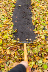 Laub kehren im Herbst Autumn Garten Park zusammenfegen