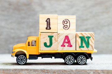 Truck hold letter block in word 19jan on wood background (Concept for date 19 month January)