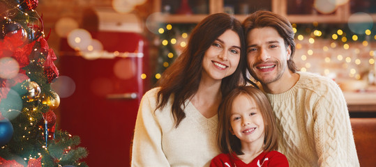 Cheerful young family posing over decorated kitchen
